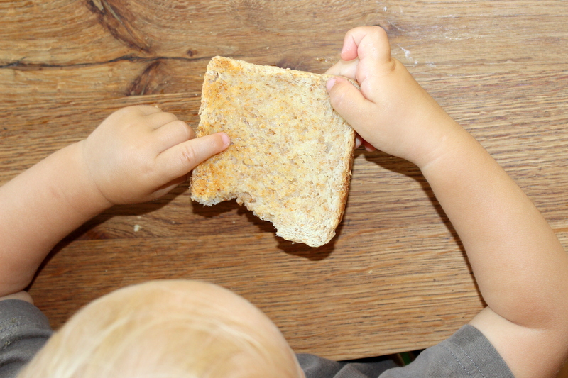 Baby isst Scheibe Toastbrot