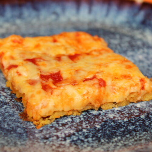 leckere Pizza mit Linsen im Boden und Käse obendrauf