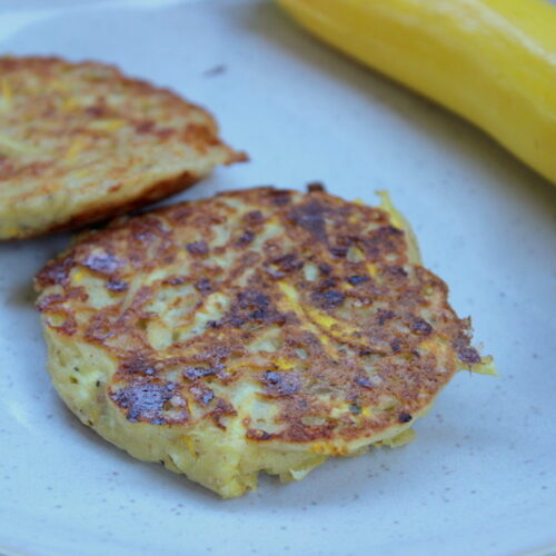 zucchini burger auf einem weißen teller mit zucchini daneben