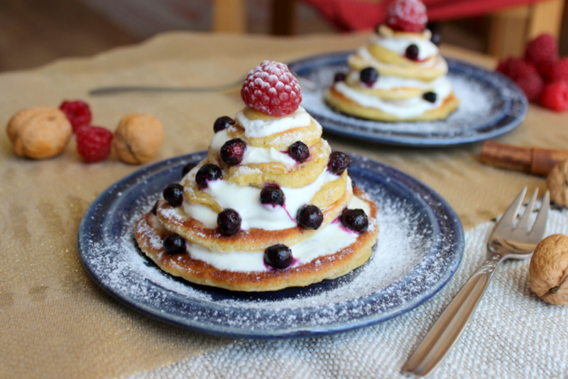 Weihnachts-Pancakes als Tannenbaum auf blauen Tellern